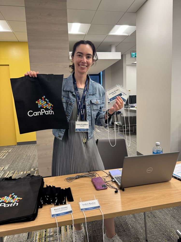 Tamara holding up a CanPath swag bag and name tags.