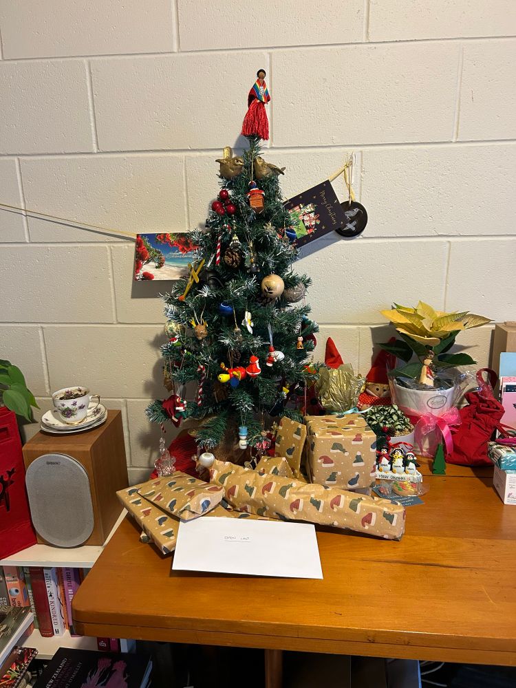 Another closer up picture of the tree and my Secret Santa presents. Behind the tree on the wall is a ribbon with a couple of Christmas cards on it. 