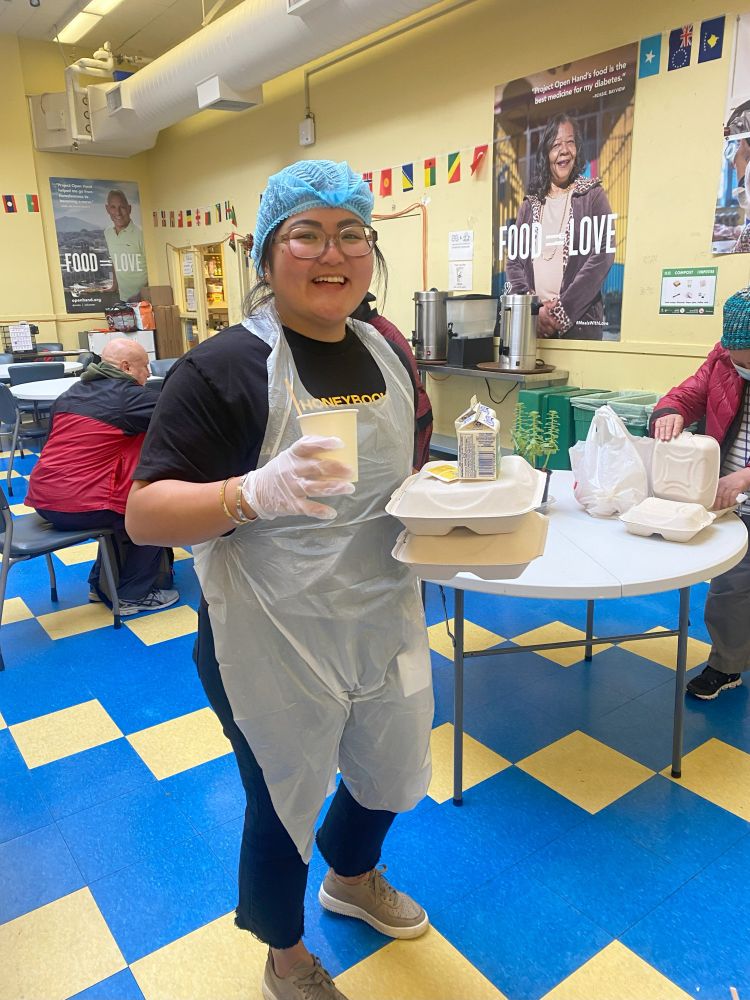 A volunteer poses with meals that she will hand out. 