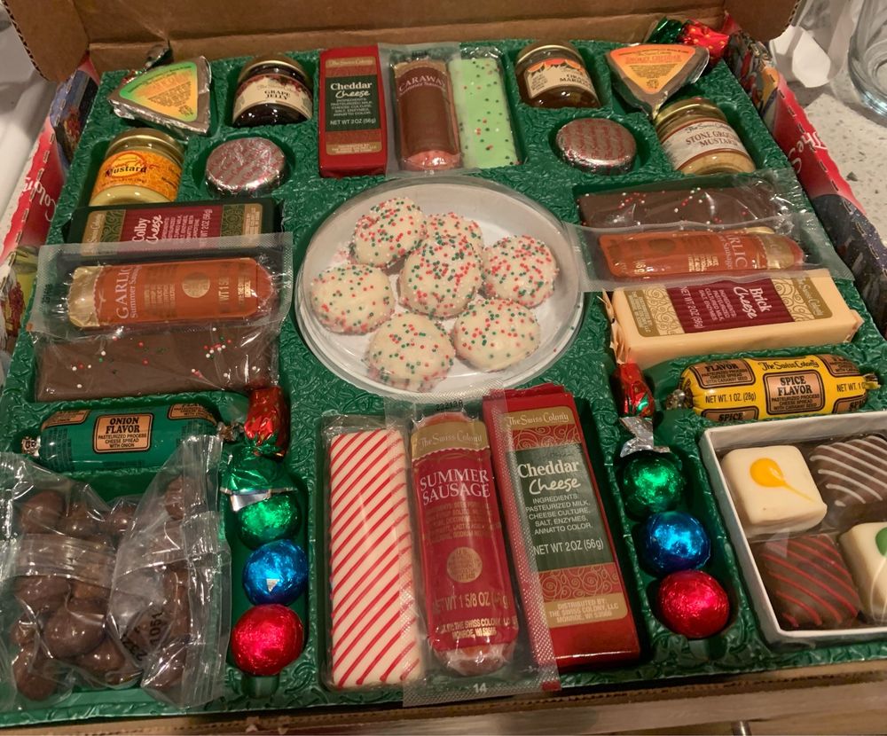 A gift box assortment of cheeses, sausages, chocolates, mustard, jelly, cookies and mini tortes