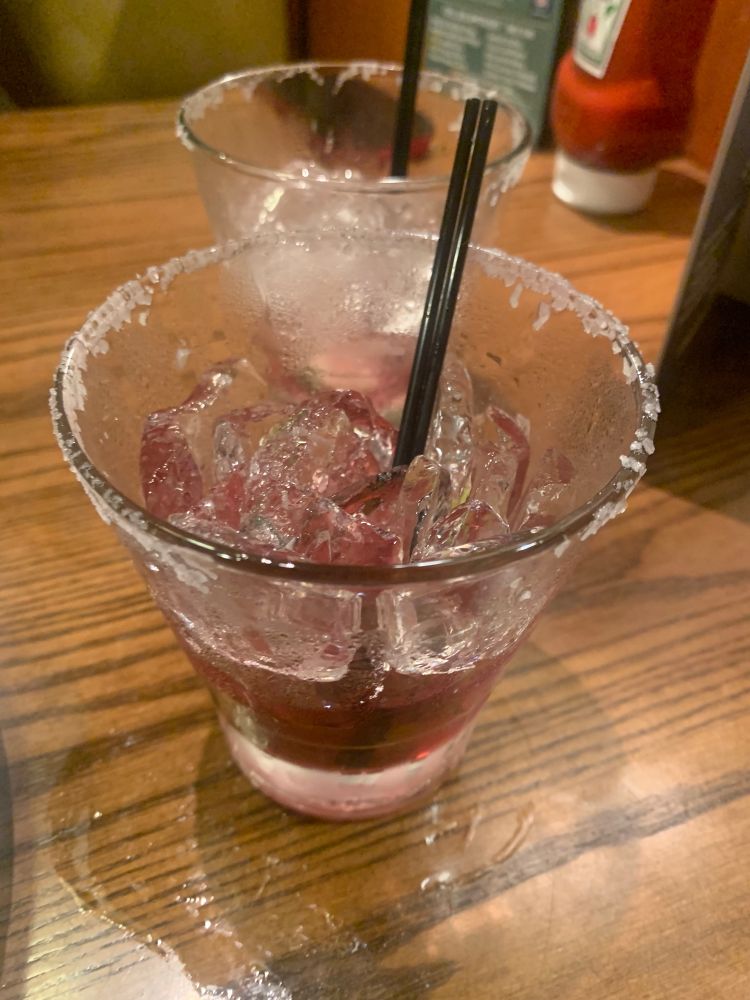 Empty and almost empty margarita glasses with salt rim