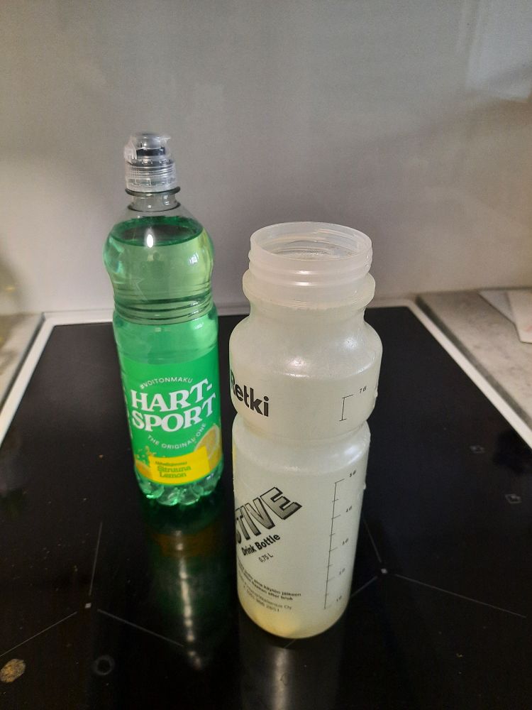 Lieden päällä yksi pullo vihreätä Hartsport-urheilujuomaa ja yksi treenipullo, jossa elektrolyyttijuomaa