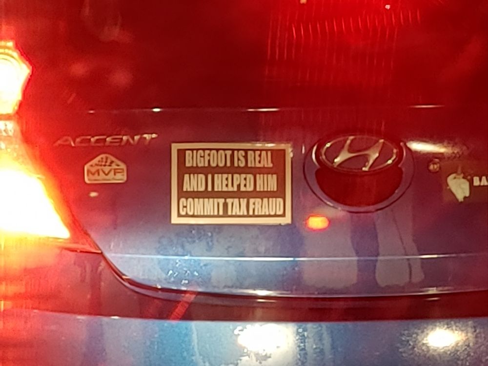 A vehicle's rear ended sticker that reads "Bigfoot is real and I helped him commit tac fraud"