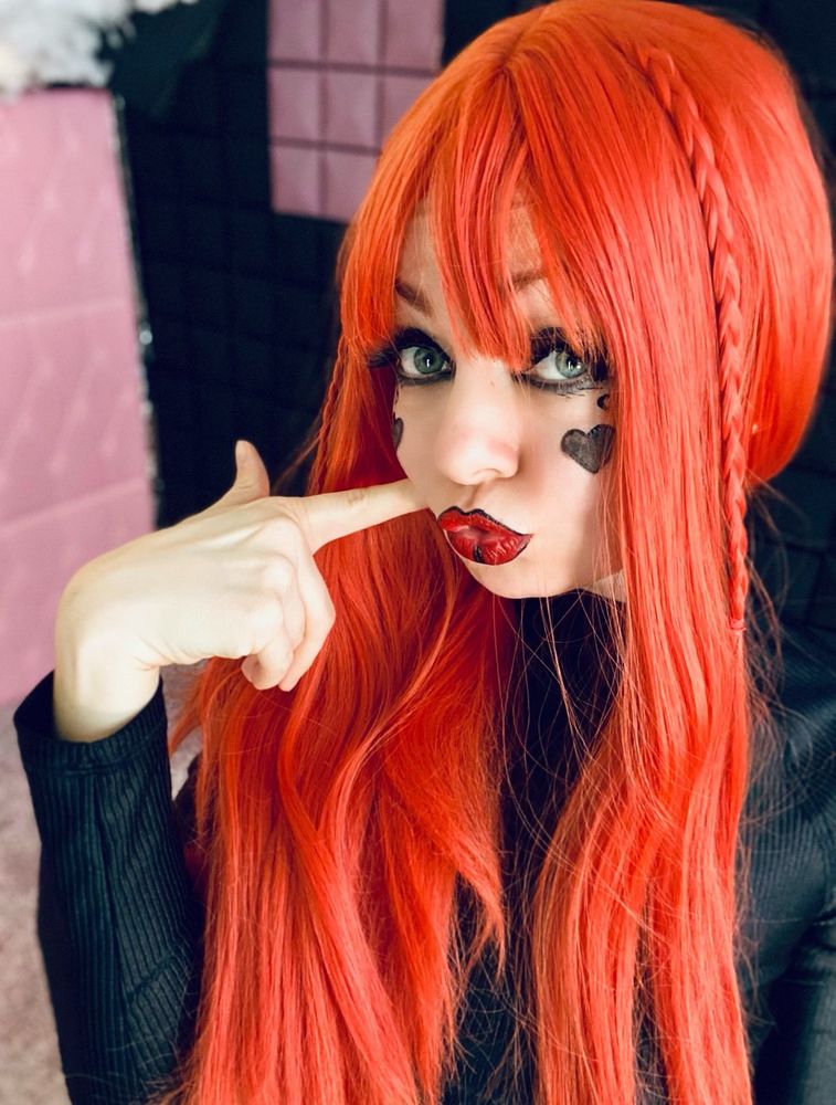 Redhead women portrait photo. She touching her cheek with her finger