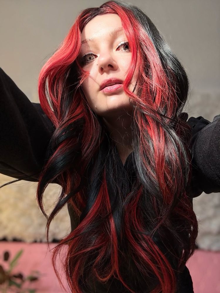 Portrait photo of a woman with long black and red hair
