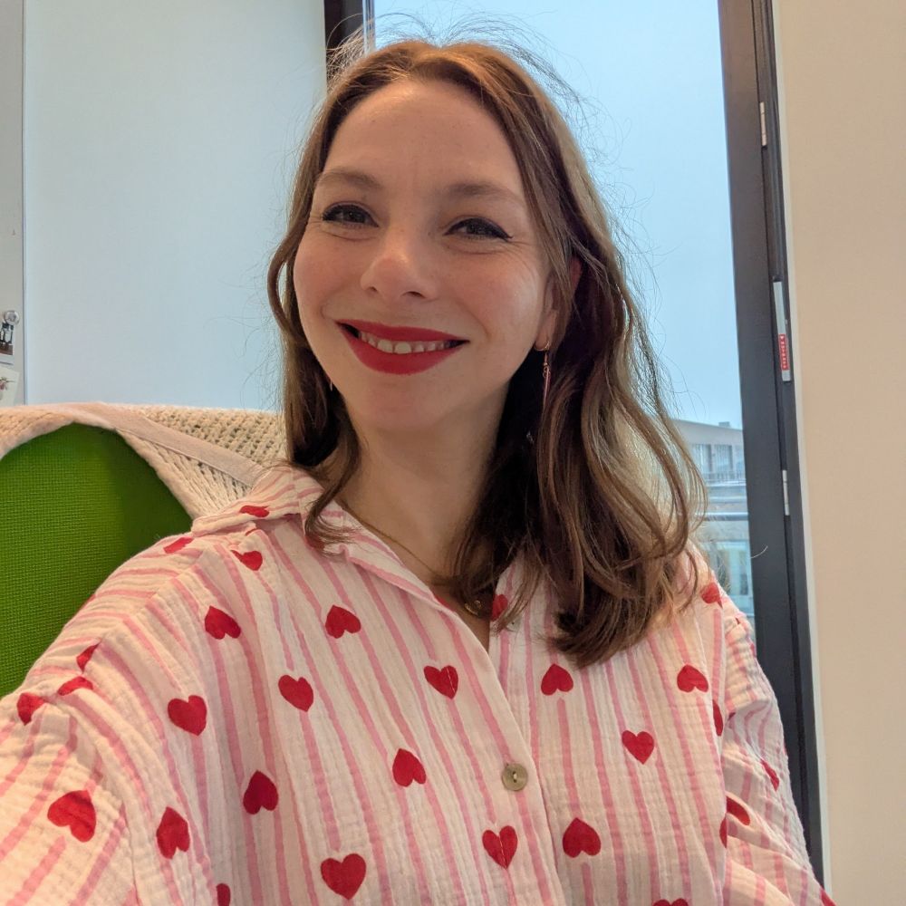 Me in a white oversized shirt, it's white with pink stripes and has little live hearts all over it. I'm also wearing red lipstick and heart shaped earrings.
