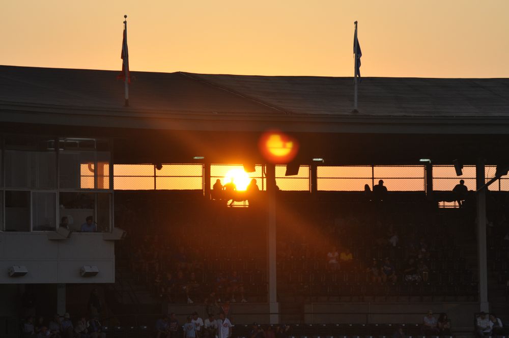 Setting sun shining through the upper deck of Wrigley Field.