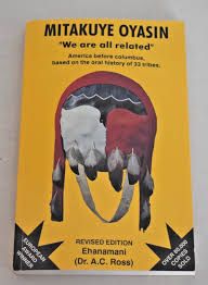 Book cover for Dr. AC Ross’ “Mitakuye Oyasin” A shield or bag painted red on the right, white on the left and black across the top portion. It has 8 eagle feathers hanging from the bottom and is set against a yellow background.
