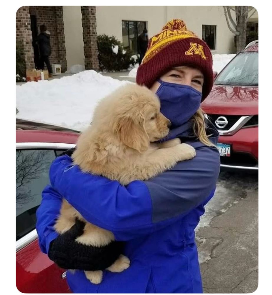Melissa Hortman and her dog Gilbert. The dog is a big pup. She holds him in her arms. Her mouth is covered by a COVID mask. Her eyes are radiantly happy. 
