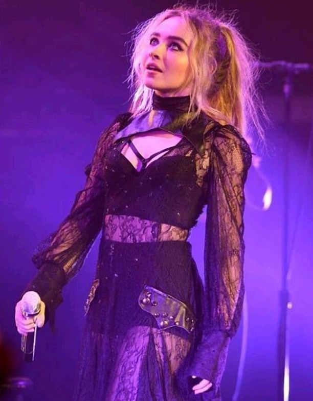 Sabrina Carpenter mirant al cel amb un micro a la ma