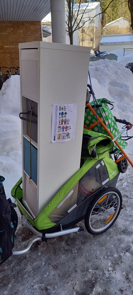 A bike trailer with a 150cm x 50cm shelving unit placed vertically inside.