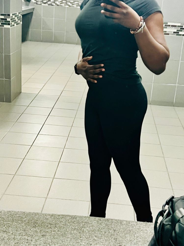 Sheron posing in gym mirror wearing black leggings