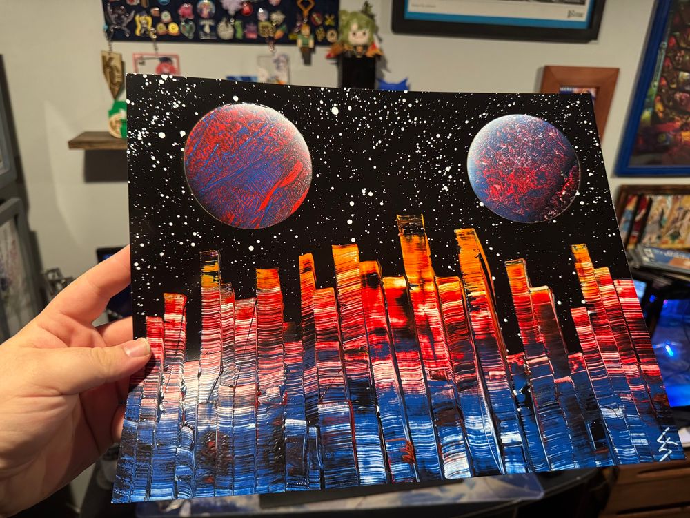 A spray paint art piece of two planets over a city skyline