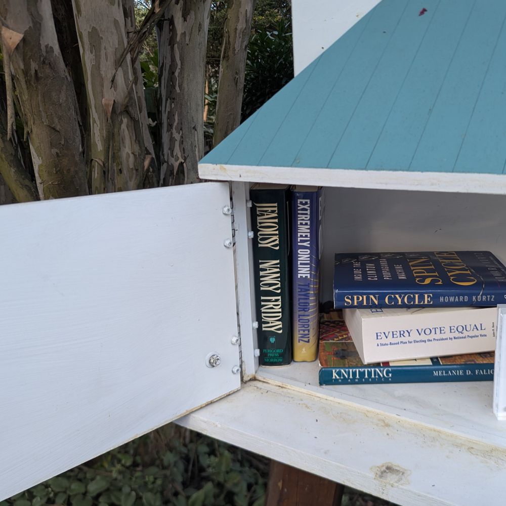 A little free library with a copy of Extremely Online on the shelf. 