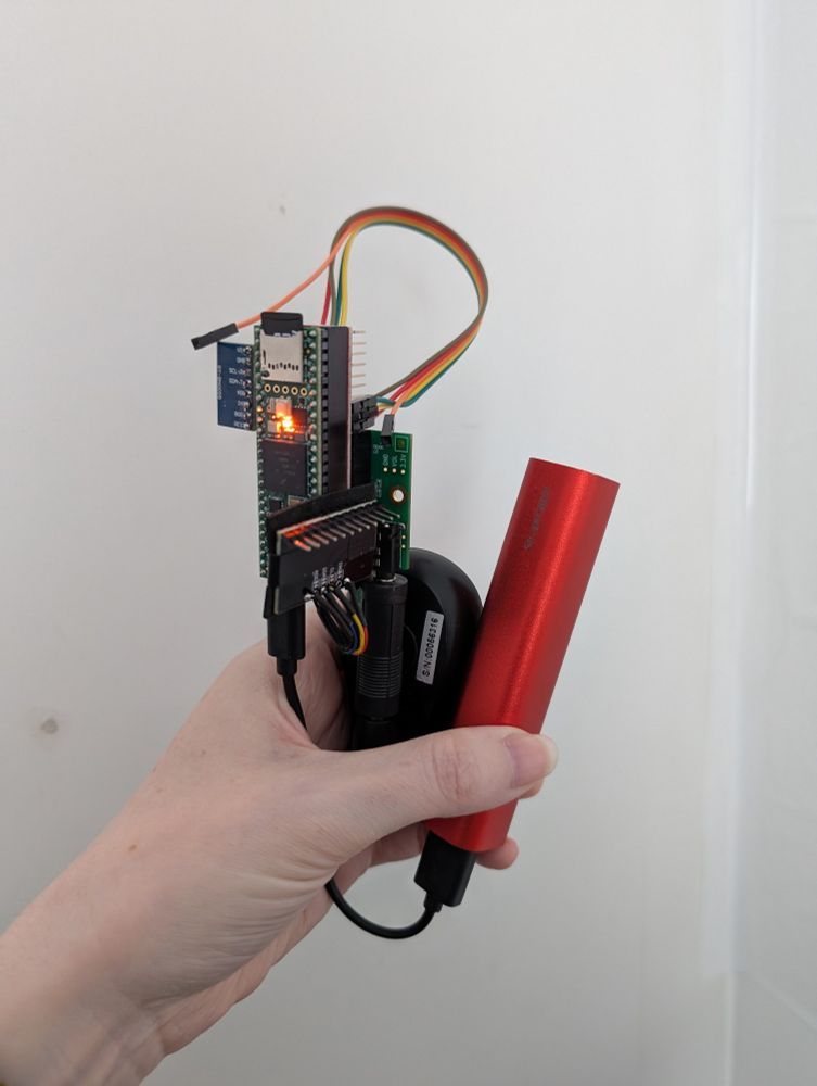 Hand holding a single board computer with connected boards and wires