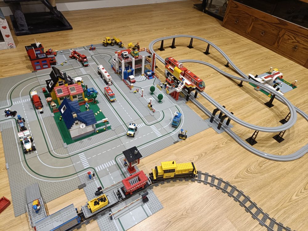 A layout of Lego road plates, a monorail, goods train, and various buildings and vehicles dating back to the late 1980s, 90s and early 2000s