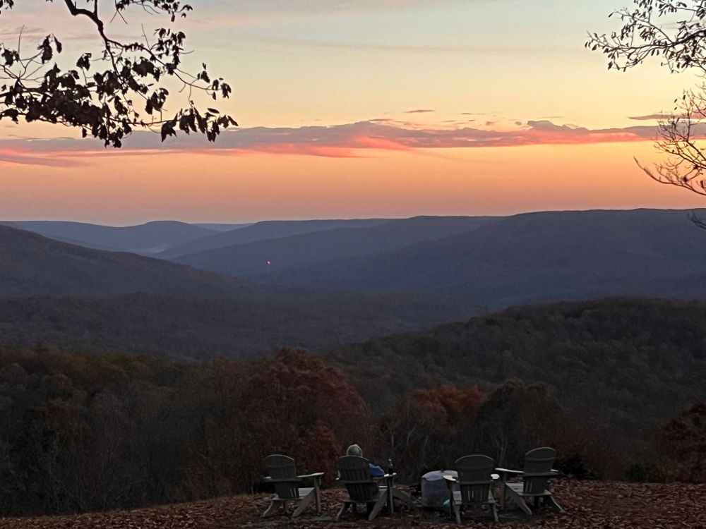 A view of rolling hills at sunset with wispy clouds. 
