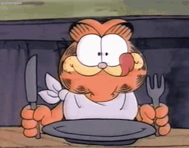 garfield is licking his lips while holding a knife and fork and a plate .