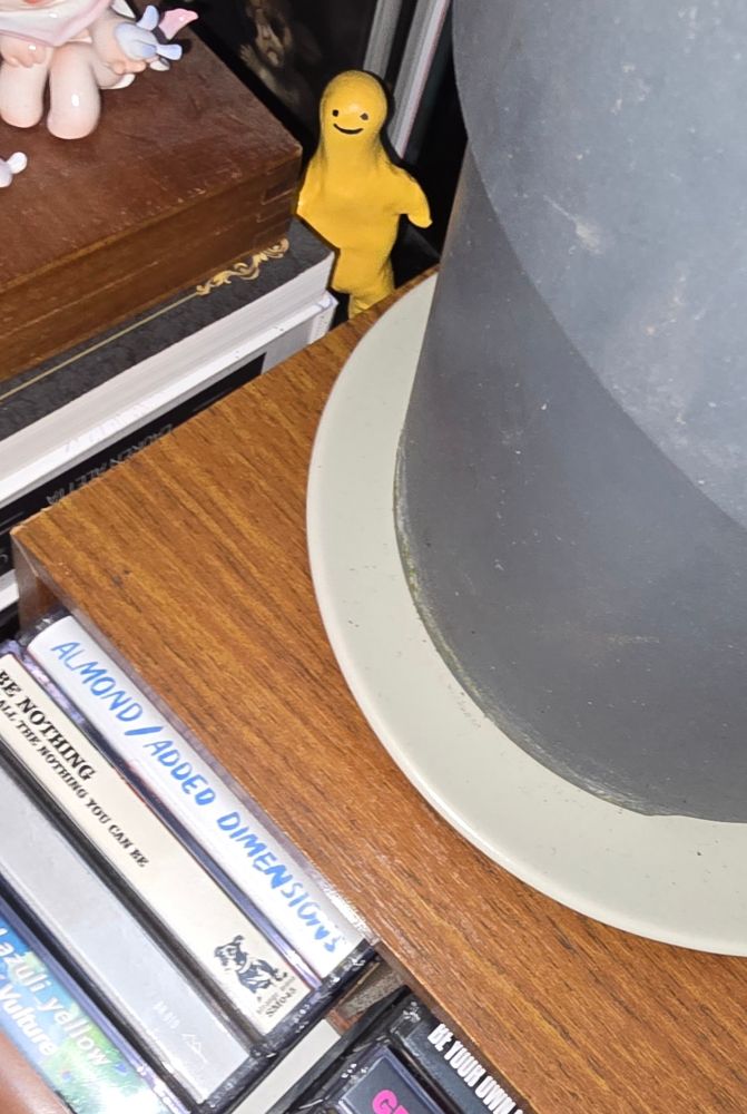 une figurine d'un petit bonhomme simpliste jaune qui souri