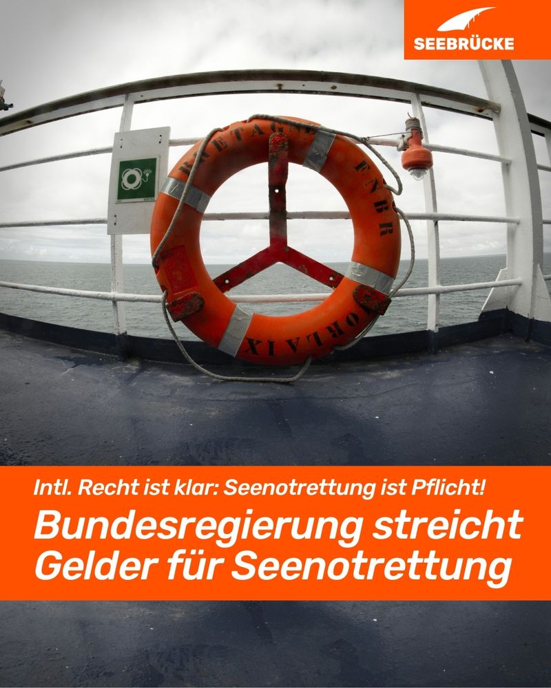 Foto einer Schiffsreling mit einem orangen Rettungsring. In einem orangen Kasten steht "Intl. Recht ist klar: Seenotrettung ist Pflicht! Bundesregierung streicht Gelder für Seenotrettung". In der rechten oberen Ecke ist das Seebrücke-Logo in weiß auf orange.