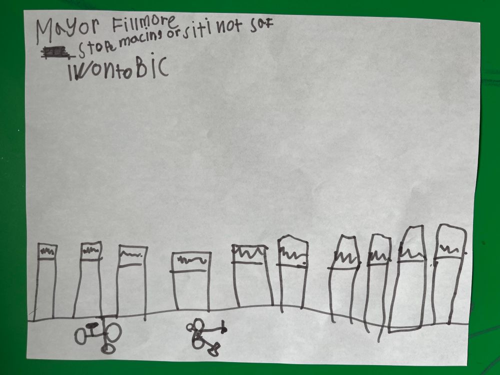 A child’s drawing of a bike lane protected by MANY bollards. There is a bike marking drawn in the lane, and a child’s tricycle stands alone in the lane.

The text at the top reads “Mayor Fillmore stop macing or citi not saf I wonto bic”