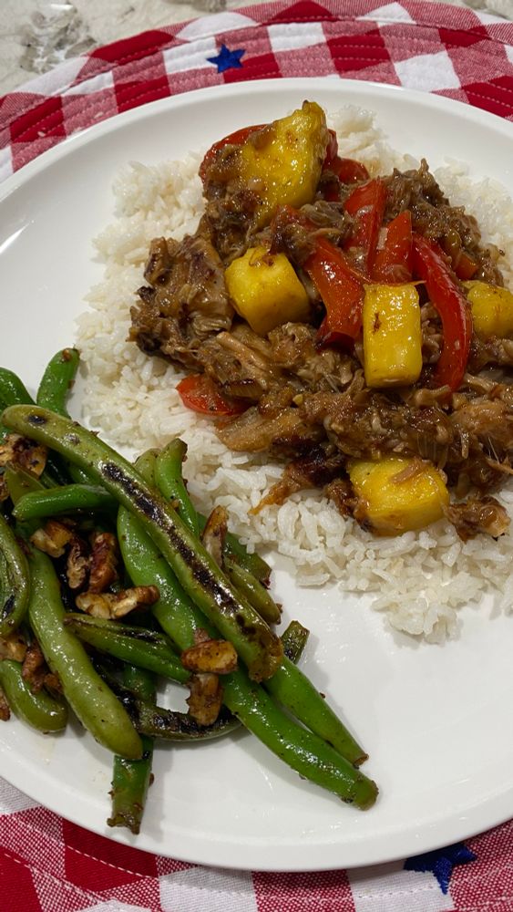 A plate of teriyaki bell pepper pineapple pork with coconut rice, chile lime green beans with pecans