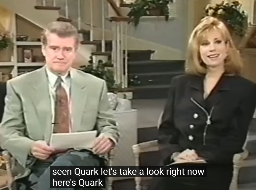 a grim-faced regis and excited kathy lee introduce quark with auto-subtitles saying "seen quark, let's take a look right now here's quark"