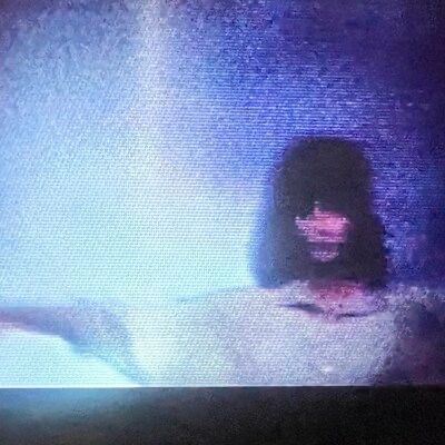 A woman in an eerie, grainy video image
