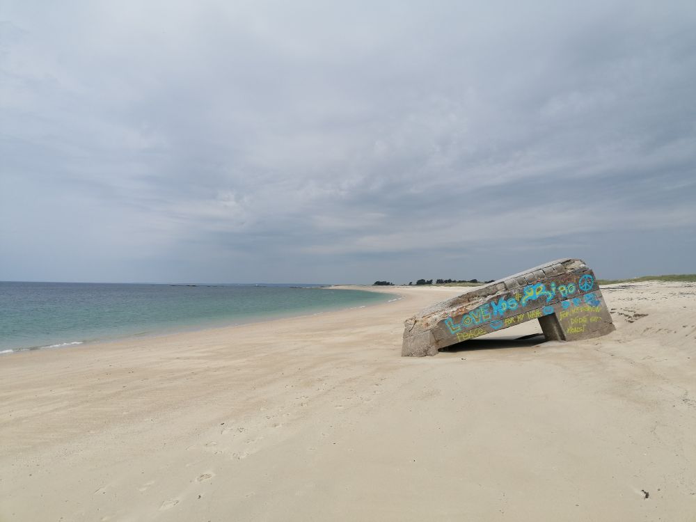 An einem verlassenen Strand steht  ein in sich zusammenfallender Bunker aus dem letzten Weltkrieg.
Auf den Bunker wurden die Worte Love und Peace aufgesprayt. 