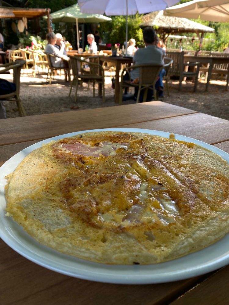 a pancake on a table in a dappled outdoor area 