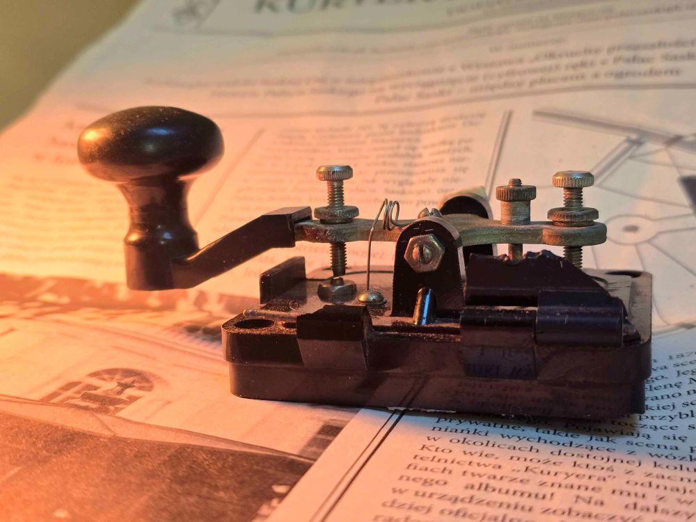DIY Arduino telegraph with huge light ray from the left side, presenting it proudly on top of 1920s newspapers.