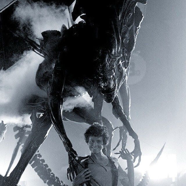 Sigourney Weaver standing happily with the Alien queen