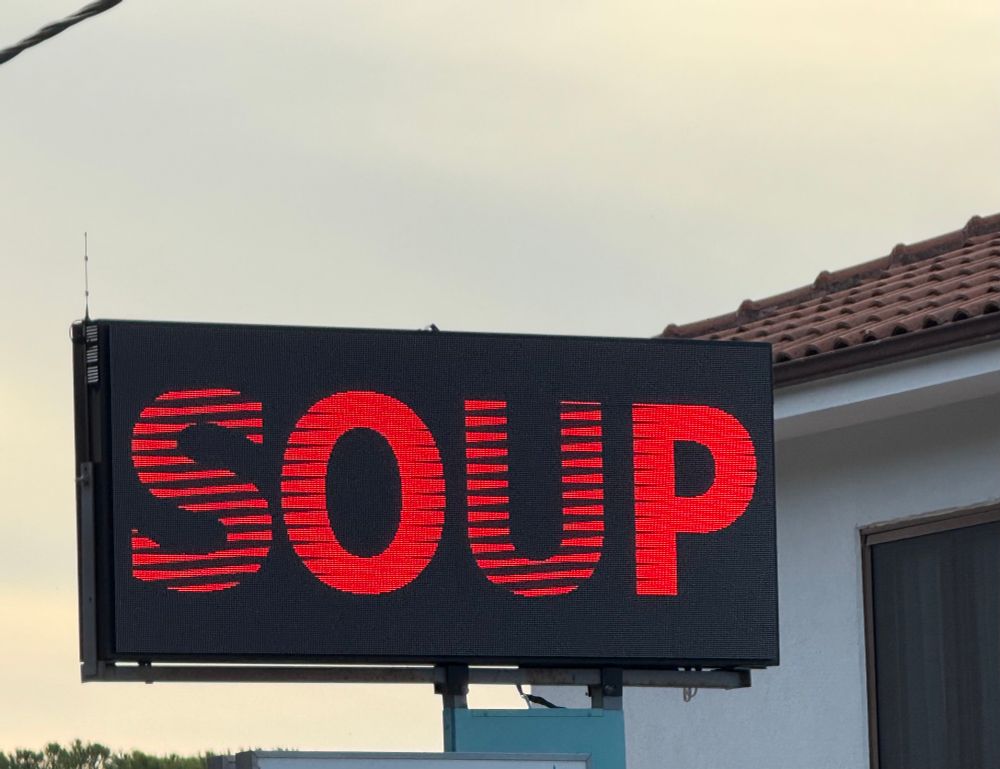 A giant electronic billboard displaying in ten foot tall letters of fire the word SOUP