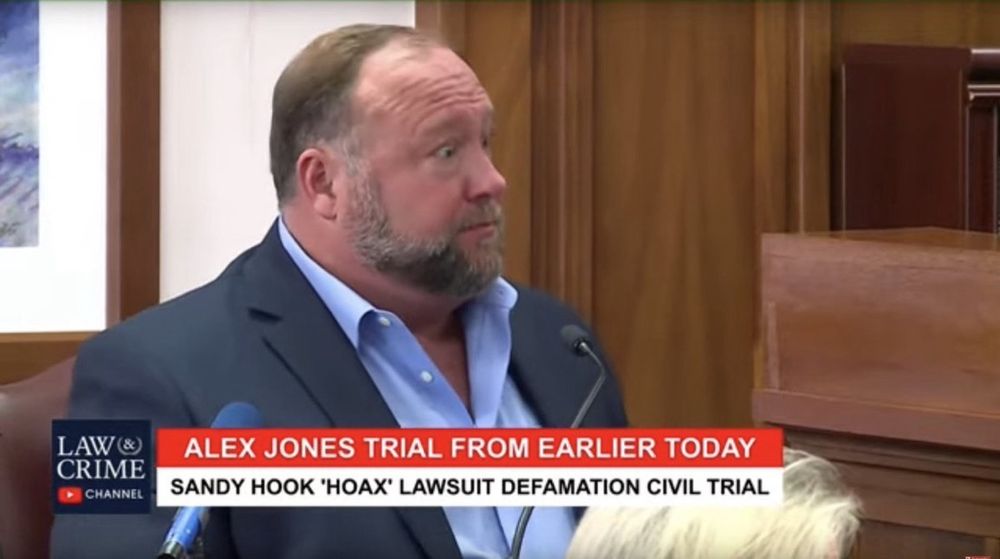 Alex Jones has wide eyes and a red face as he gets caught lying under oath. 