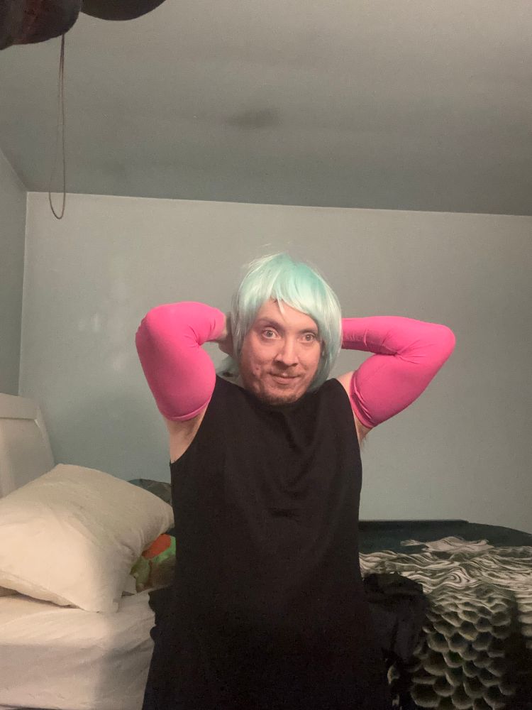 Girl in black dress with a mint wig and beefy arms 