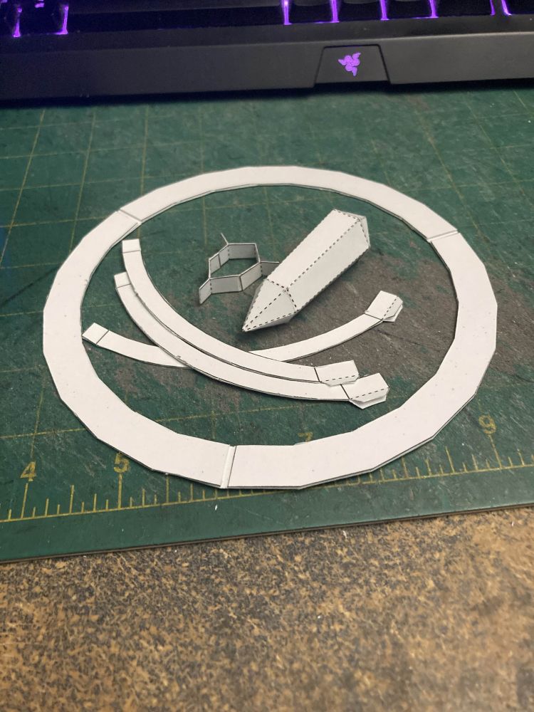 A paper model, deconstructed into its parts. This allows it all to store compactly, but also allows the parts to be interchangeable. Different textured bases, ropes or chains, and lots of different crystal options!