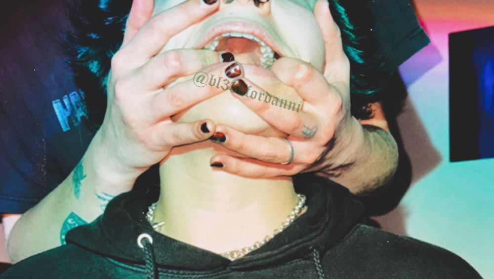 Danni has their fingers firmly grasping their partners face and pulling on their cheeks as they shove their fingers further down their partners throat. Their partner is particularly vulnerable and caught up as they get gagged.