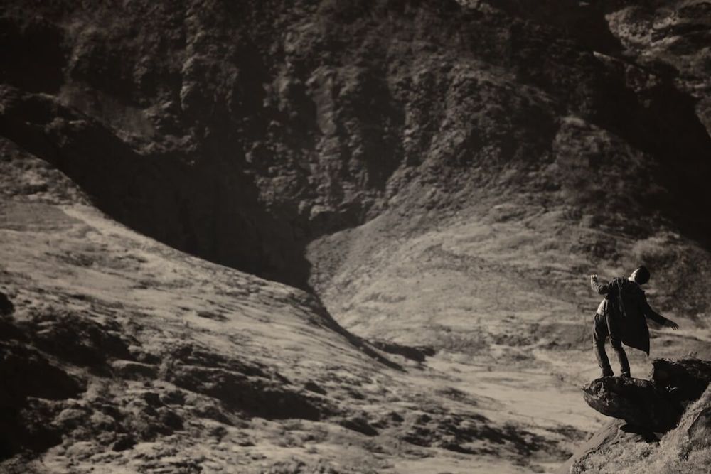 Image: Clare Langan: Elizium, 2014 | greyscale photo or photo-like image of a figure in a bleak, bare-hills landscape (possible Iceland?); the figure is off to one side on an outcrop above what seems would be a serious drop; the figure is leaning to the right, dark-haired and wearing a cloak – operatic buzz • “SO Fine Art Editions is proud to announce the opening of our annual photography exhibition, ‘Drawing with Light’, showcasing nine leading Irish and international photographers. The exhibition opens on 05 July, 2025 and runs until 28 July at our Dublin gallery on the second floor in the Powerscourt Centre.    This dynamic group show features work by Diane Arbus, Philip Arneill, Michael Corrigan, Conor Horgan, Clare Langan, Loretta Lux, Fionn McCann, Brían Sparks, Amelia Stein, Sudi and Dominic Turner. From documentary realism to conceptual abstraction, ‘Drawing with Light’ explores photography’s power to tell stories, reframe perceptions, and invite reflection through diverse…”