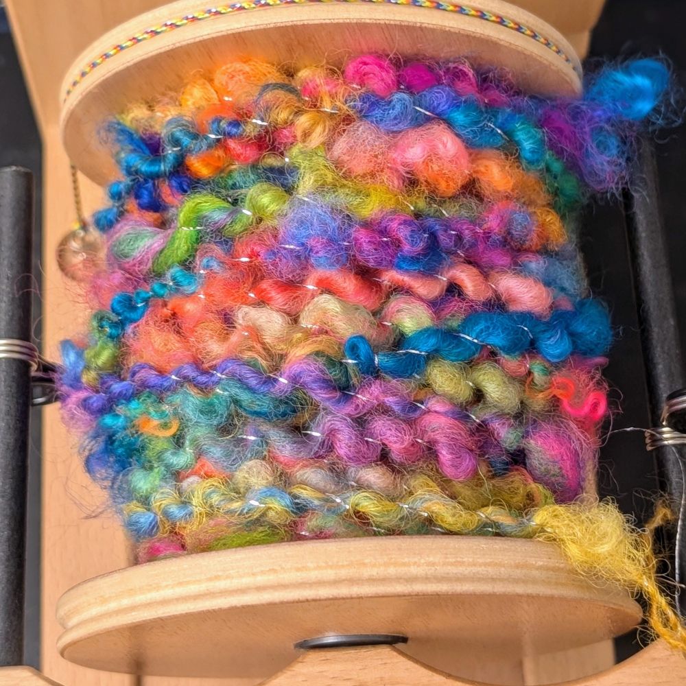 The full bobbin of very bright handspun yarn. 