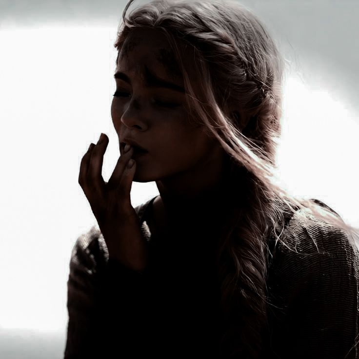 Garota com expressão pensativa, com o rosto parcialmente sombreado e os cabelos claros presos em uma trança solta ao vento.