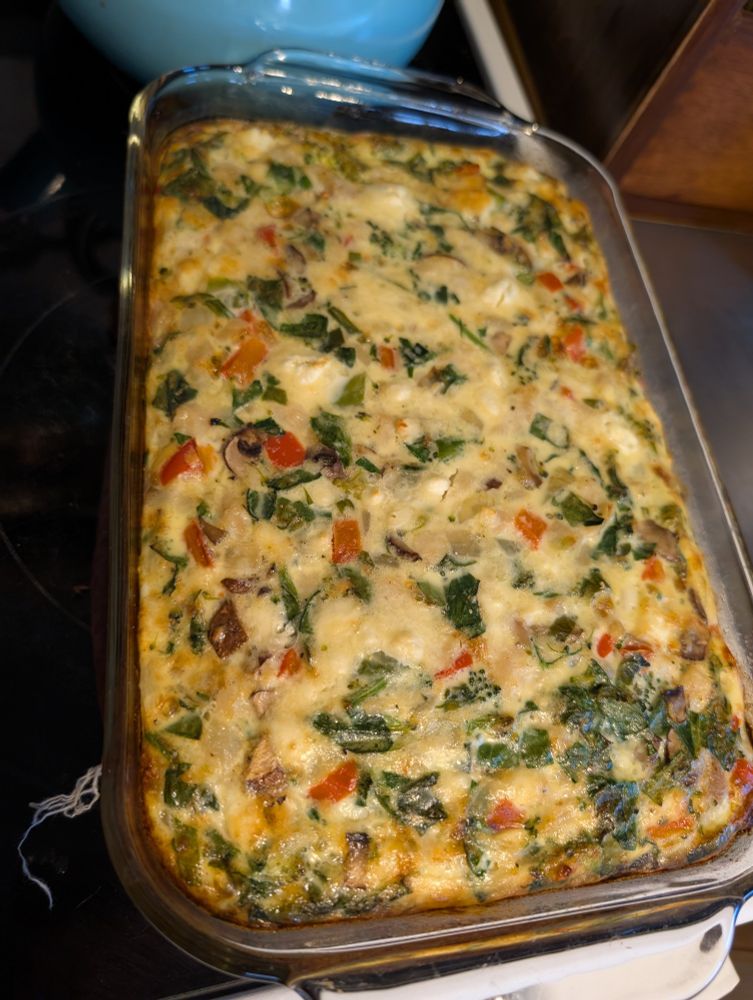 Egg bake, cooked pops of green and red from spinach and peppers.