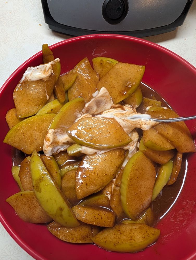 Cooked apples in cinnamon caramel sauce with yogurt