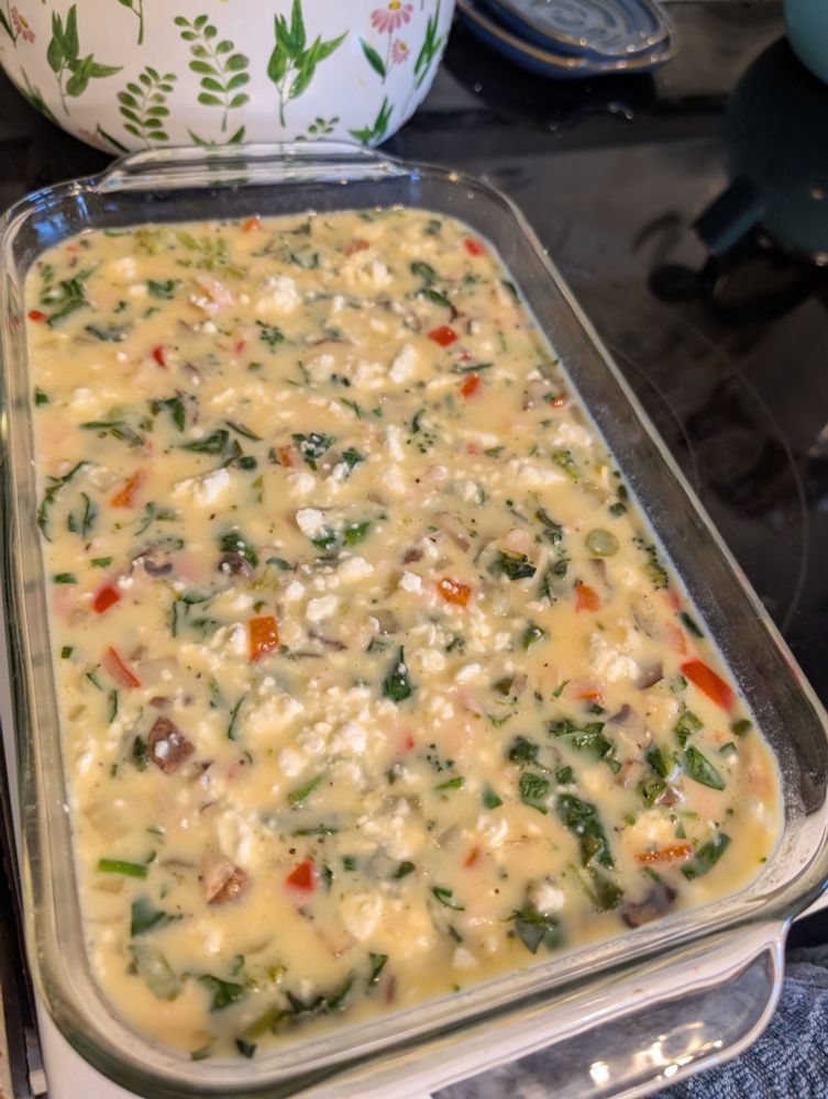 Egg bake with broccoli, spinach, peppers, onion, chicken and feta, waiting to be baked