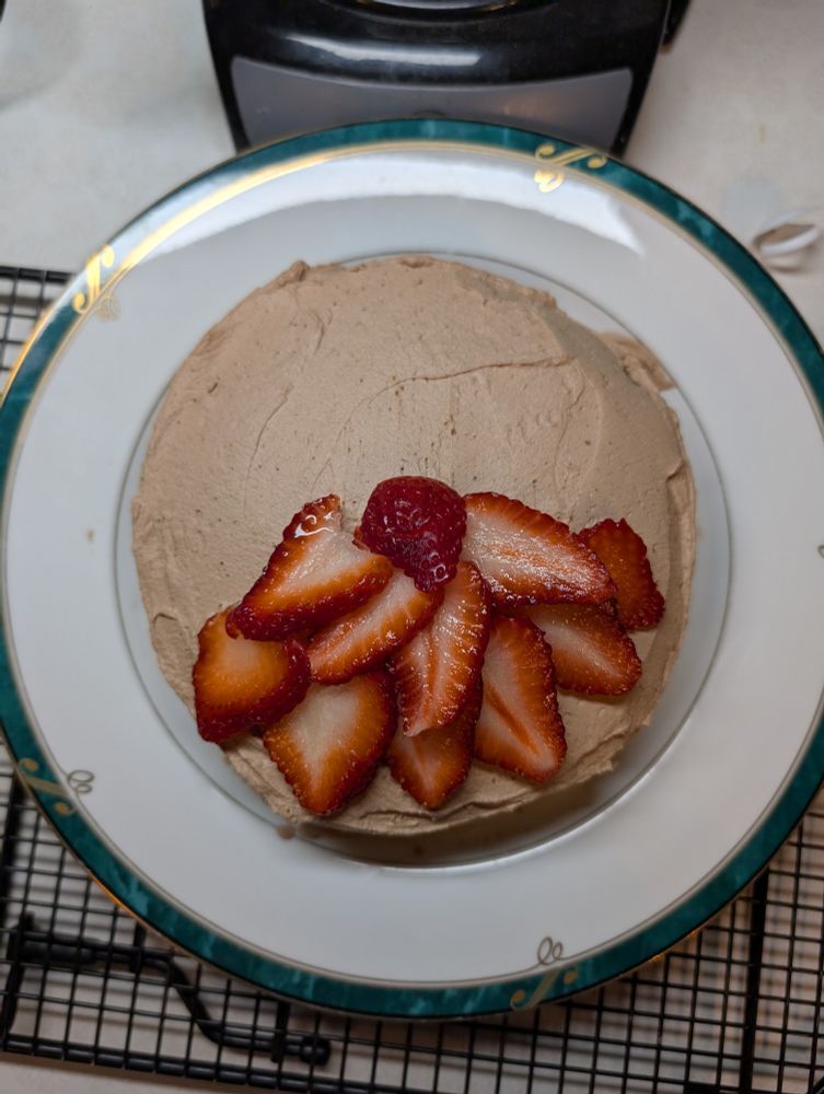 Chocolate cake with chocolate mousse frosting and sliced strawberries 