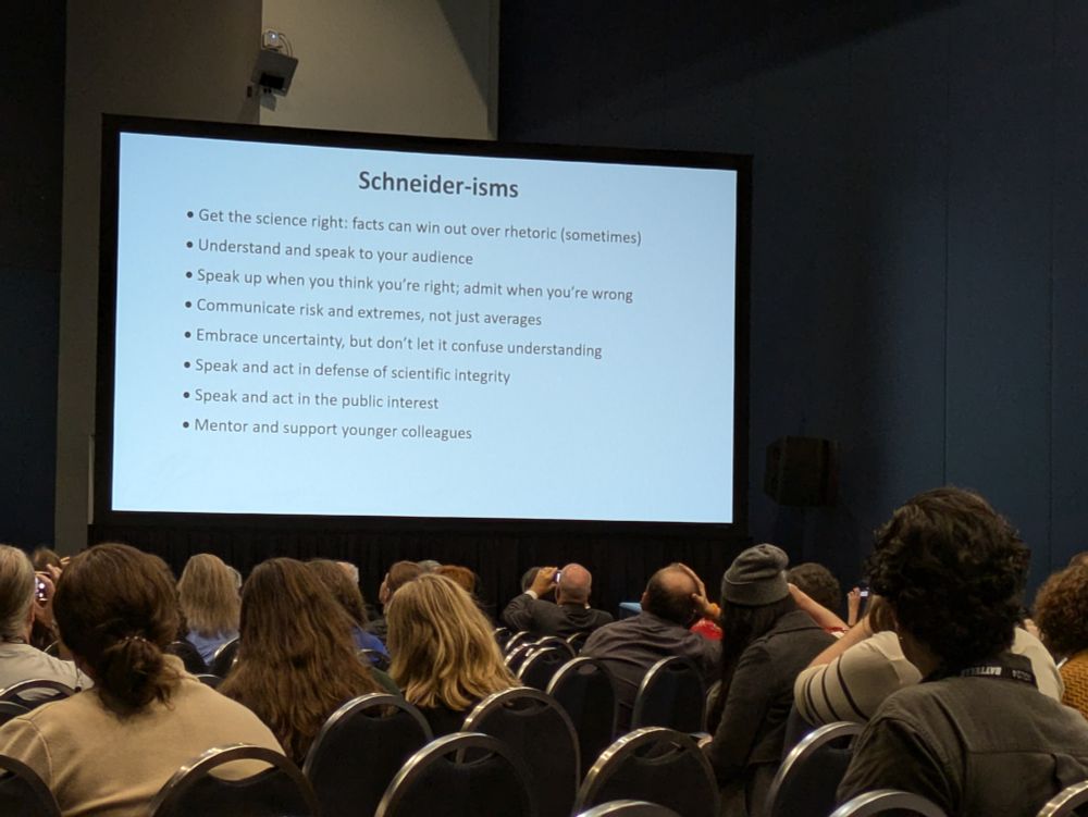 A photo of a meeting room with projected slide and audiences.