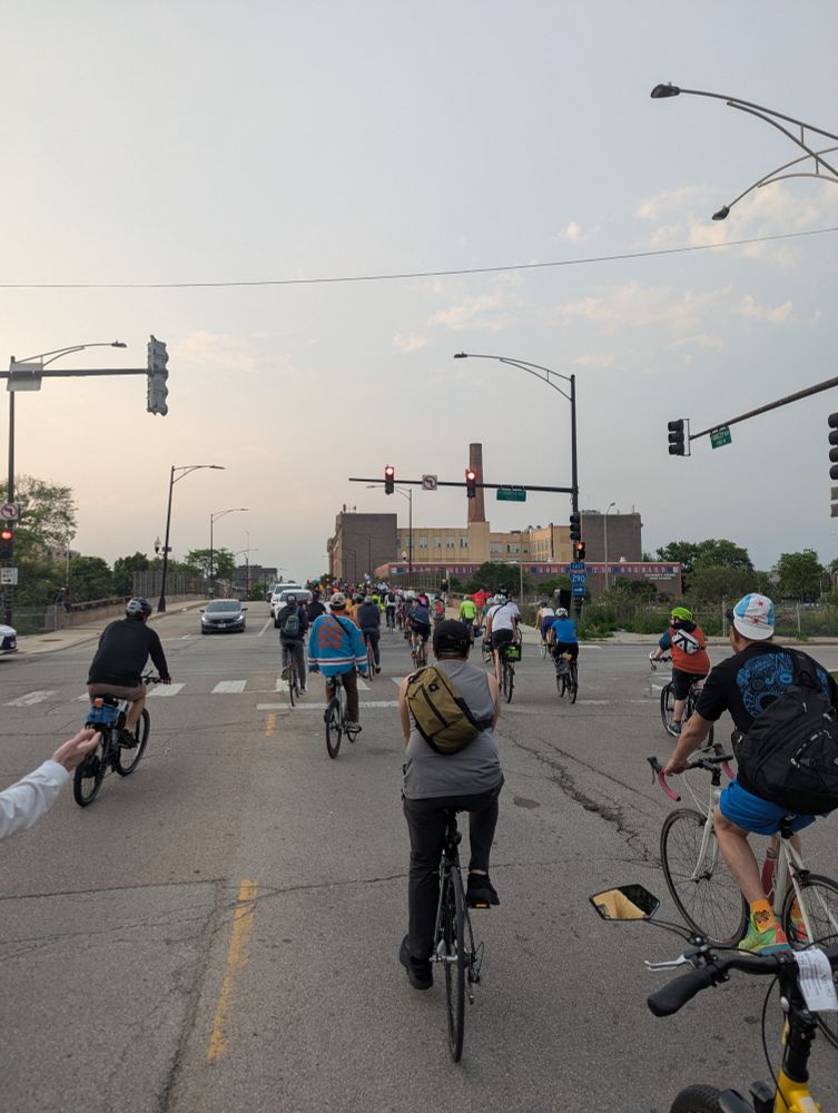 Bicyclists riding in the street for Chicago's Critical Mass. Crane Medical High School is a dope building.