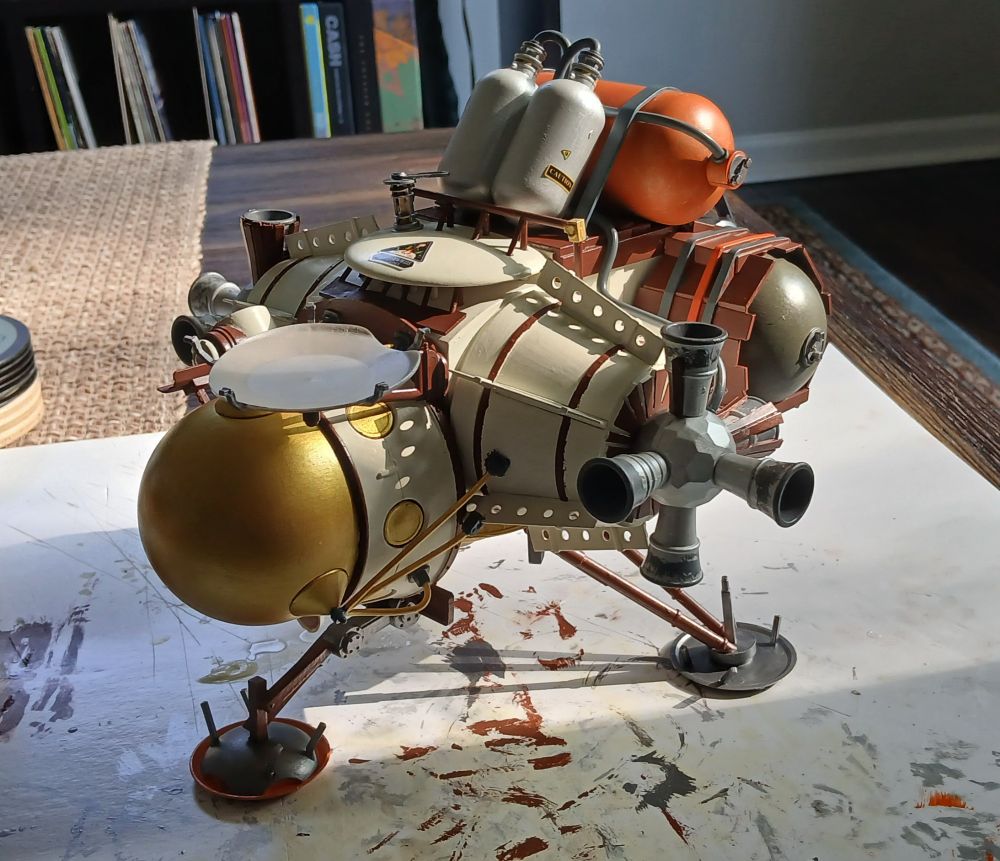 Model lander from Outer Wilds sitting on a table under the evening sun.