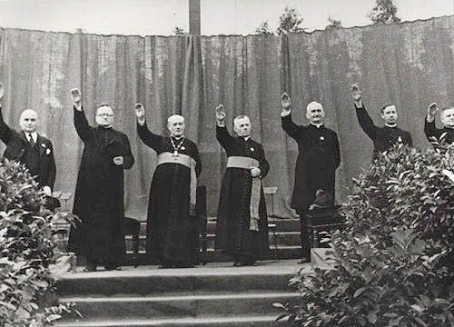 Pfaffen recken den Arm zum Hitlergruß