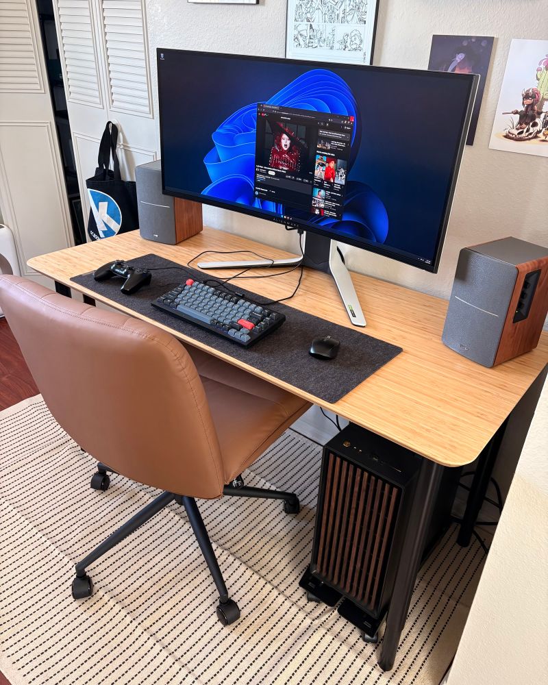 An updated shot of my apartment corner desk setup. I’ve added a rug, a different chair, and some computer speakers. I’ve also moved the cpu tower to a rolling cart under the desk.