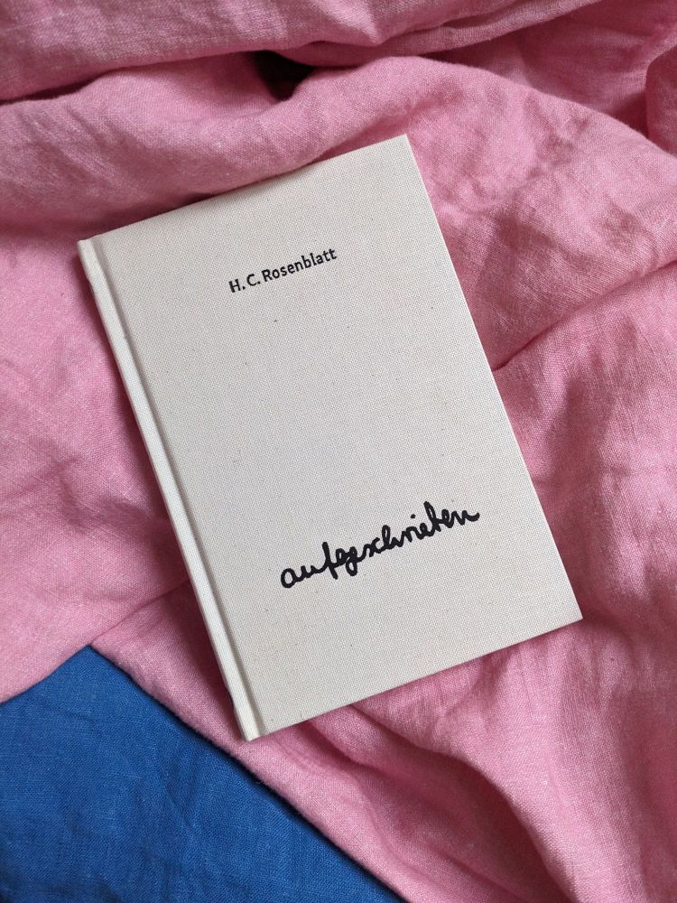 The book "aufgeschrieben" lies on a blanket.